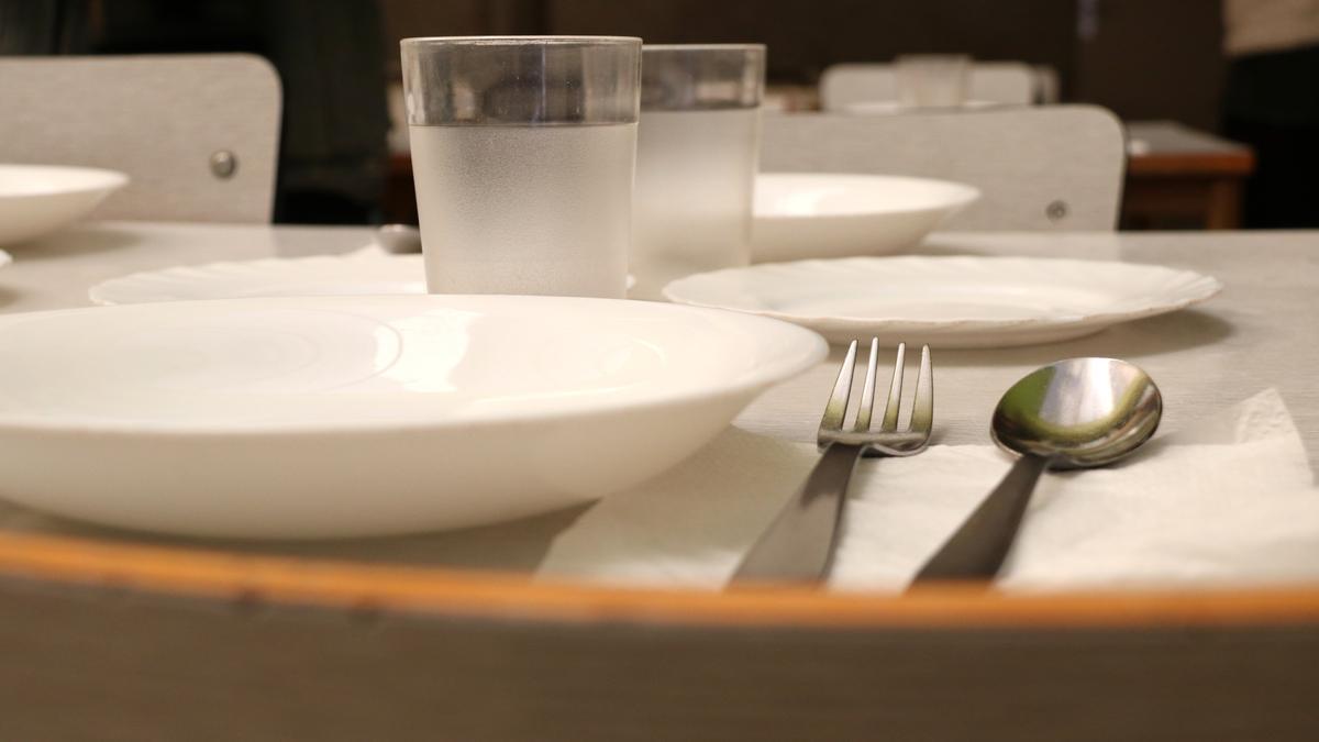 Platos y cubiertos en una mesa de comedor escolar