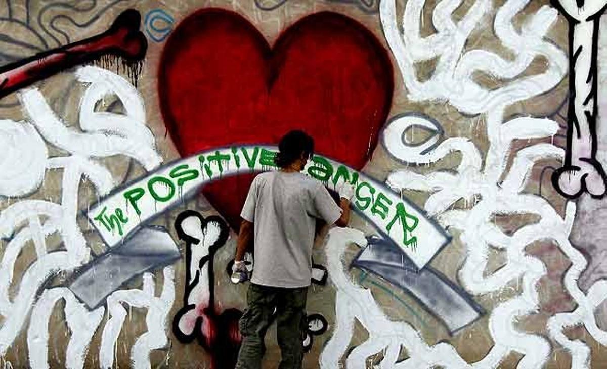 Un artista afganès pinta un grafit a la paret d’un parc industrial a Kabul (Afganistan).