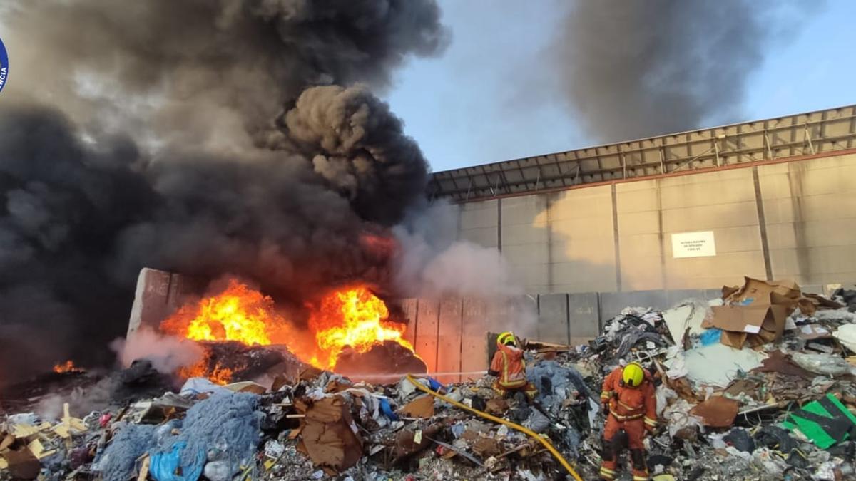 Los bomberos sofocan el incendio en la nave de reciclaje de plásticos en Alginet.