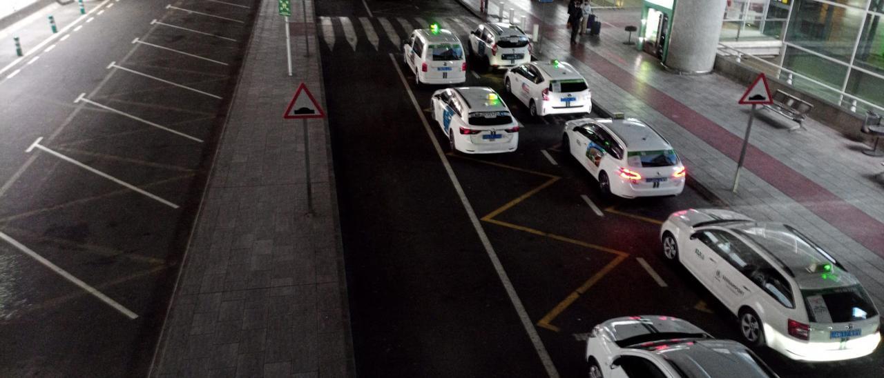 Taxis en el aeropuerto de Elche. A la izquierda, aparcamiento en batería para servicios privados de transporte