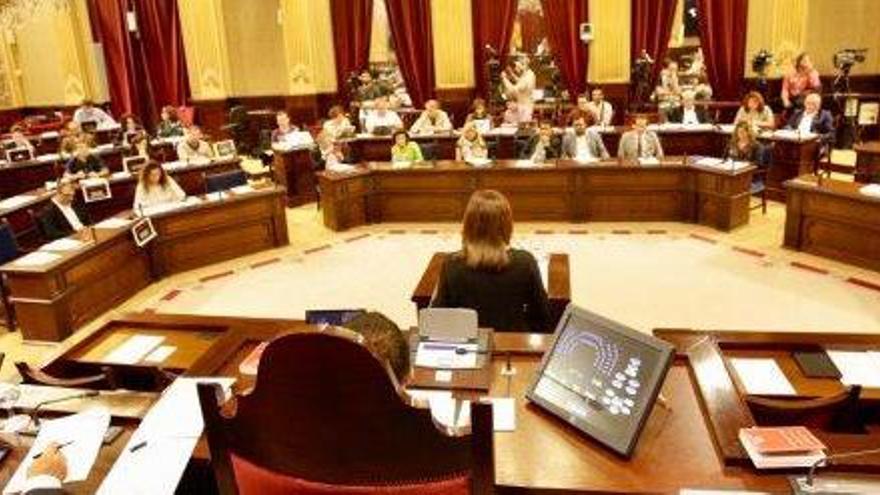 La presidenta del Govern balear, Francina Armengol, de espaldas ayer en el Parlament, frente a la bancada que ocupa su gobierno.