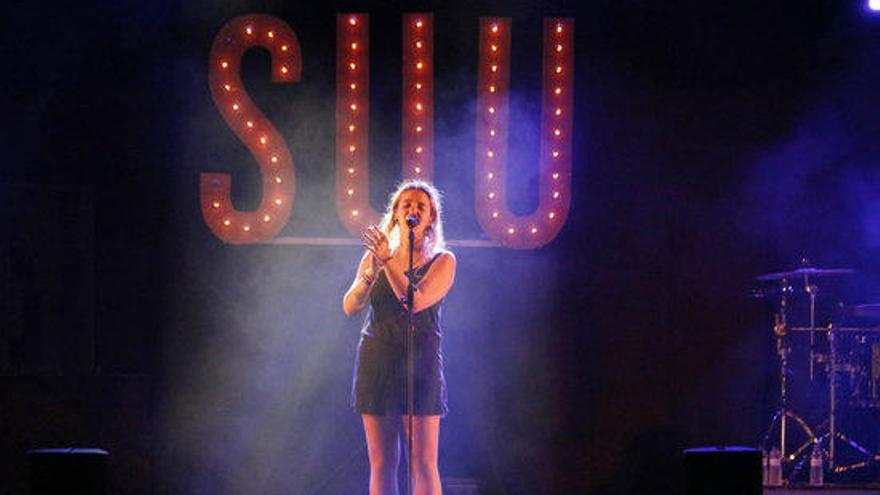 La cantant Suu amb el nom del grup de fons durant el seu concert al Festival Acústica de Figueres.