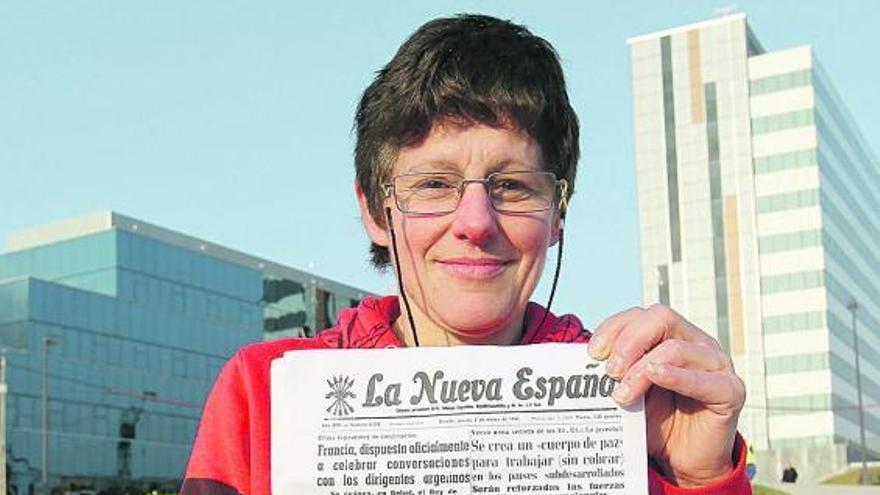 Ana Gayol, ante el nuevo Hospital Central, con una reproducción de la portada de LA NUEVA ESPAÑA del 2 de marzo de 1961, en la que aparece una fotografía suya -abajo en detalle- en una camilla.