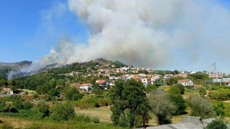 La columna de humo del incendio, muy próxima a las viviendas en Cudeiro. // FDV