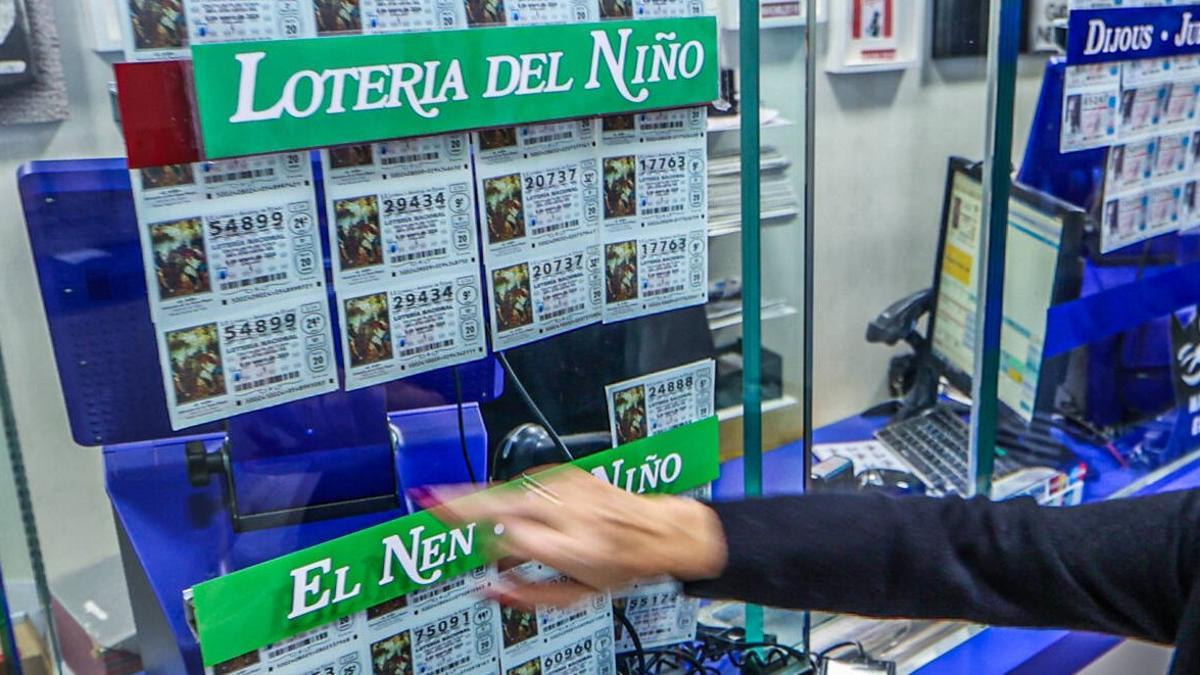 Una mujer elige un décimo para la Lotería del Niño en una administración de la ciudad de Barcelona.