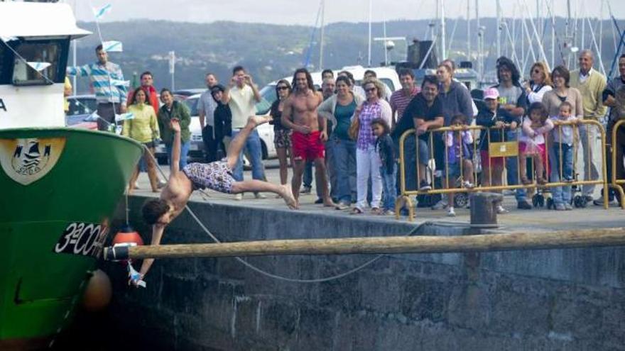 Uno de los participantes, ayer, en las cucañas de Sada. / fran martínez