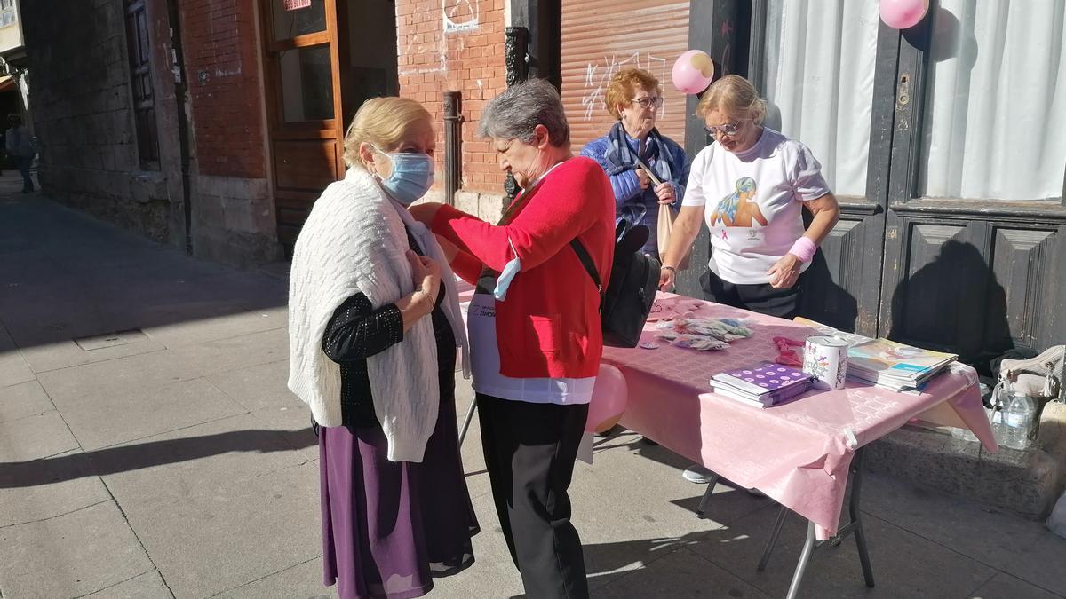 Voluntarias de la asociación reparten lazos rosas entre vecinos de Toro