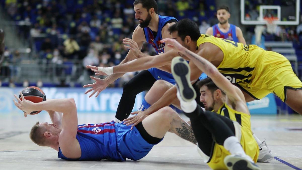 El azulgrana Roland Smits controla un balón en el suelo, presionado por dos jugadores del Fenerbahçe.