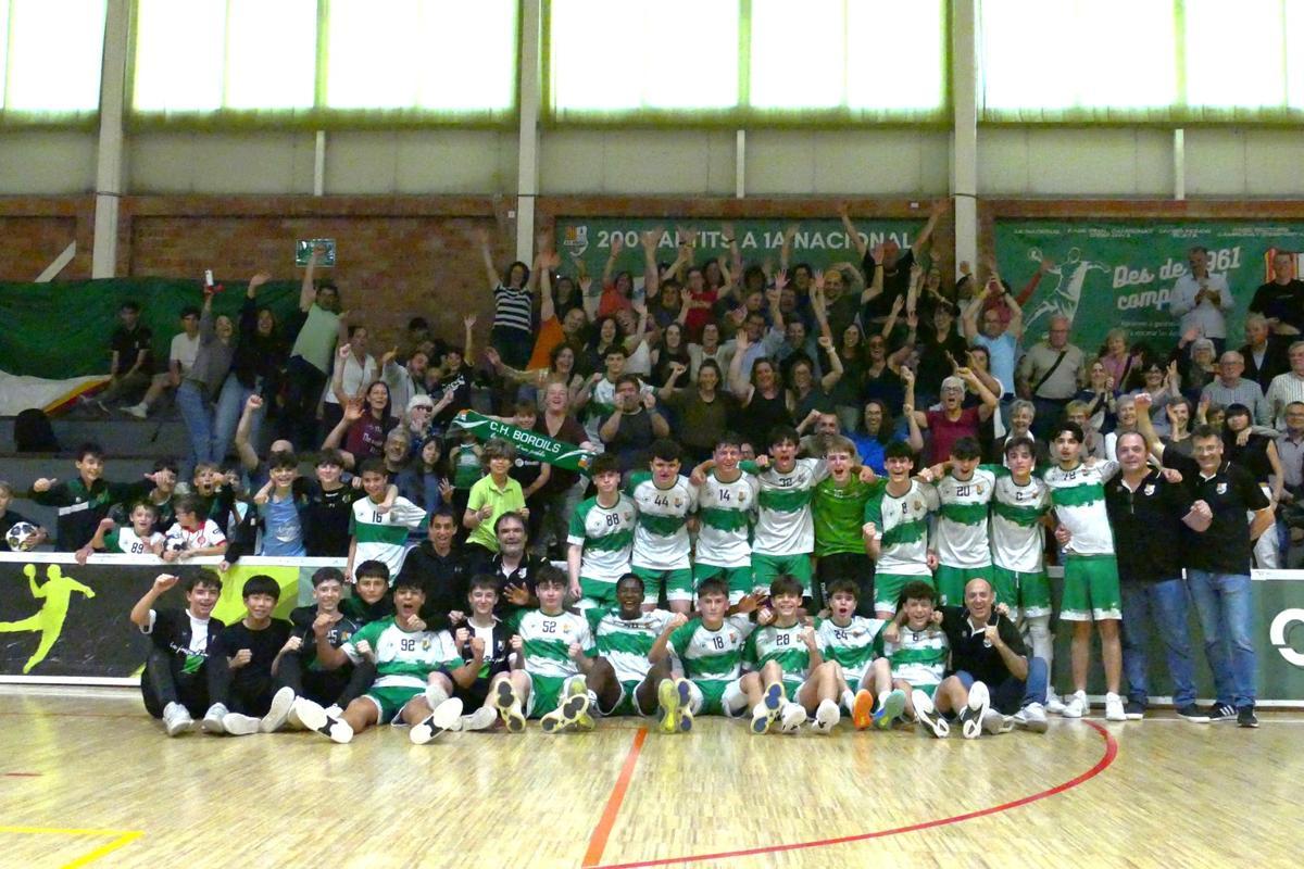 El cadet blanc del Bordils celebra la victòria contra el Barça B amb l’afició al darrere.