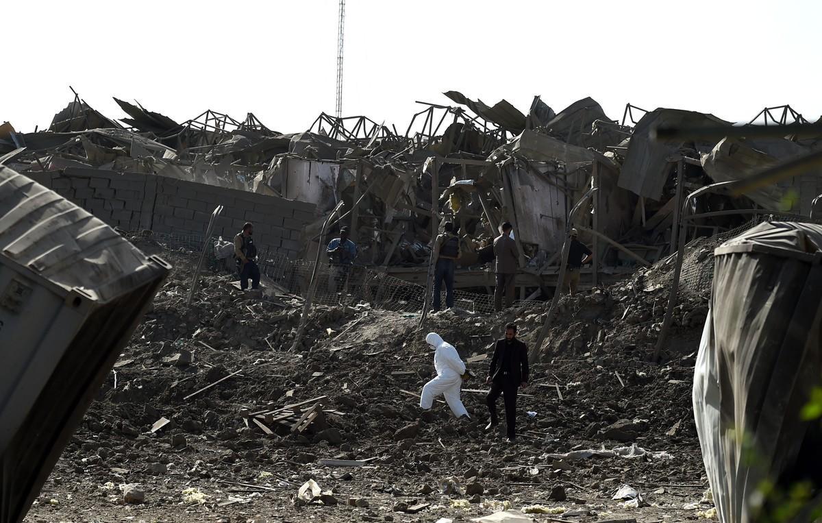 Agentes de las fuerzas de seguridad afganas inspeccionan la zona del atentado, en las afueras de Kabul.