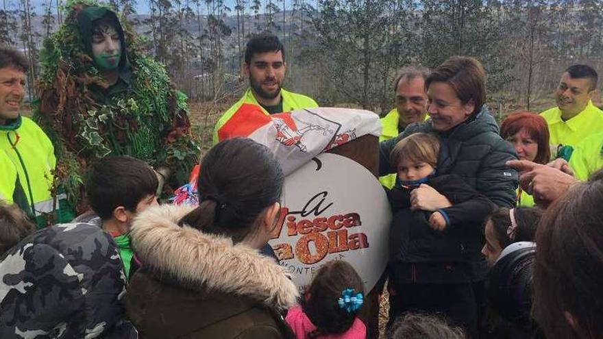 La alcaldesa, Carmen Moriyón, descubre la placa del bosque &quot;La Viesca la Olla-Monte Deva&quot; rodeada de niños y demás participantes en la actividad.