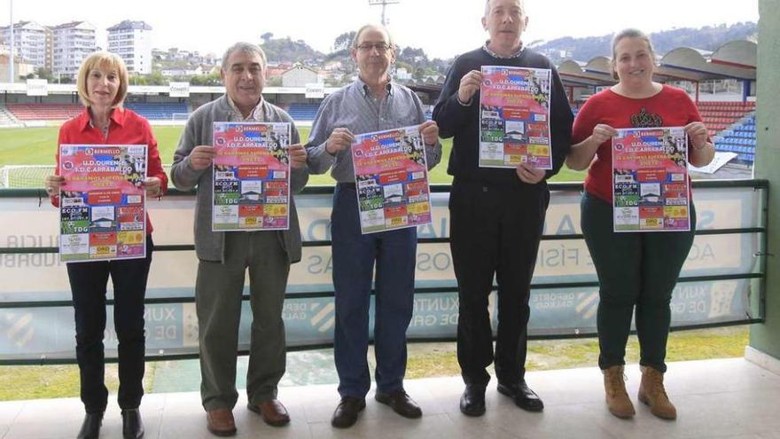 Voluntarios de la UD Ourense, ayer en O Couto, con el cartel anunciador del partido de este domingo en O Couto. // Jesús Regal