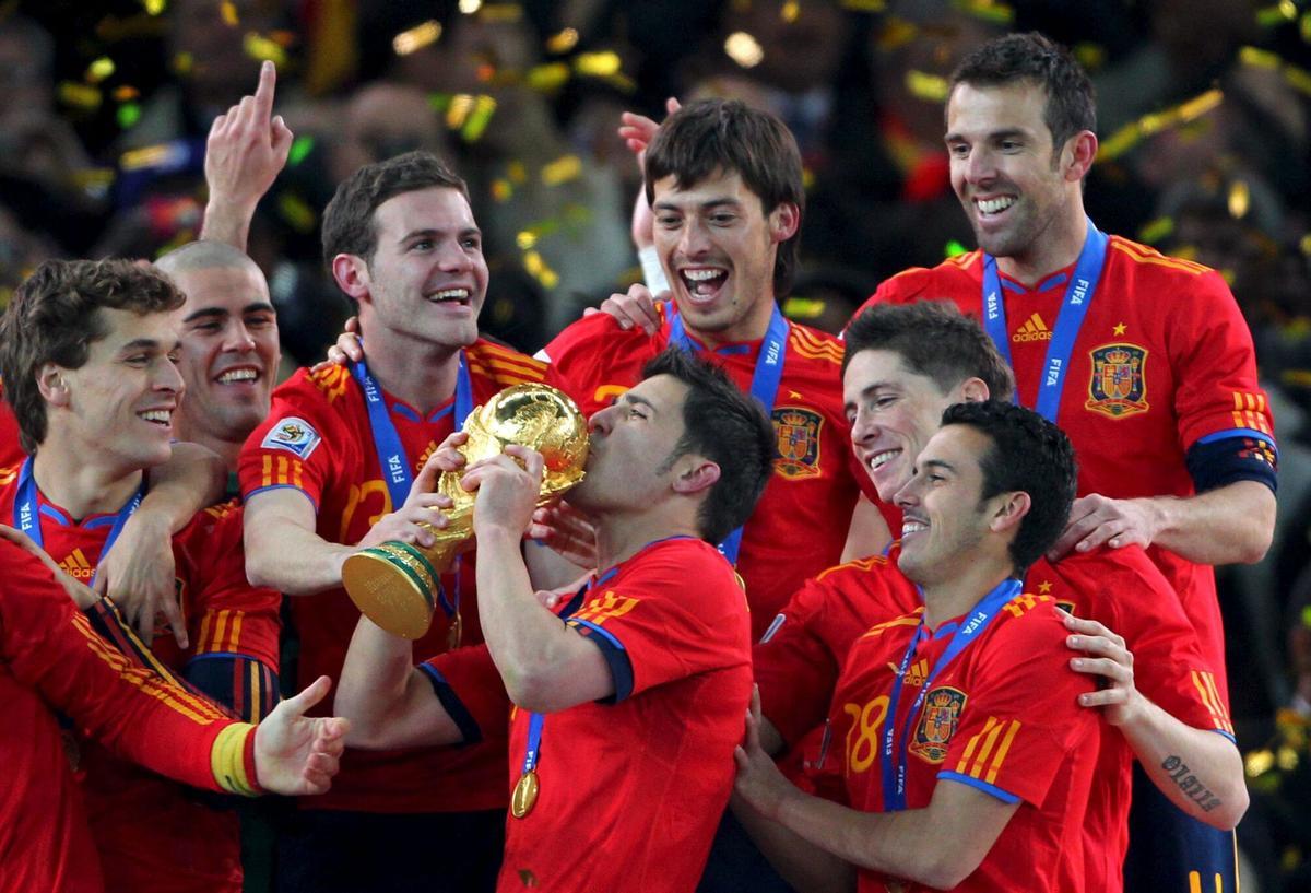David Villa besa el trofeo de campeón del Mundial de Sudáfrica 2010, rodeado de sus compañeros.