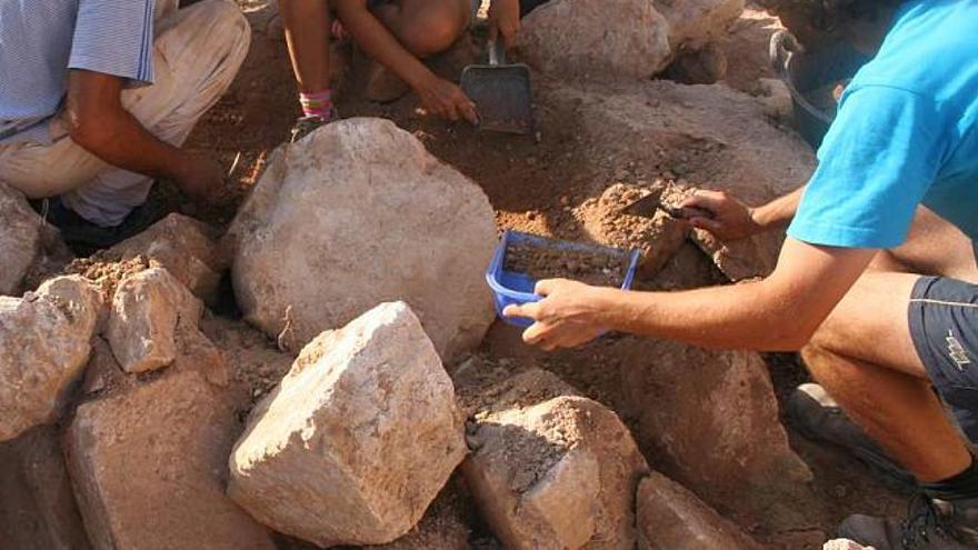 El equipo de excavaciones retira la tierra que rodea la clave de la bóveda de la antigua iglesia