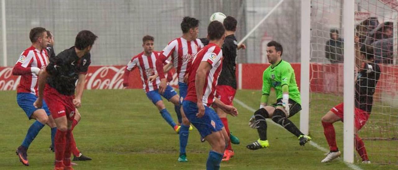 Adrián Torre trata de detener el remate de un futbolista del Sporting B.