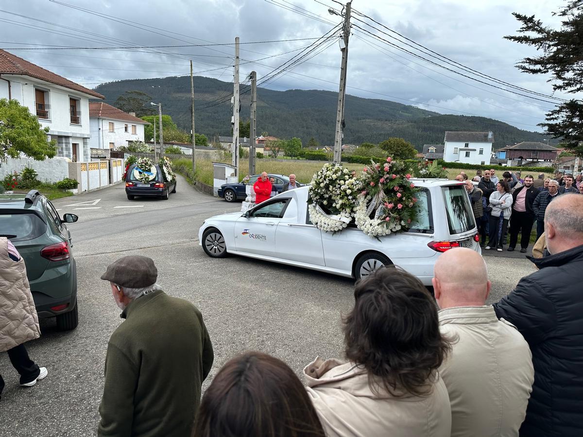Dos coches fúnebres, cargados de coronas de flores, a su llegada a la iglesia de Cadavedo.