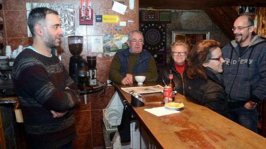 José Espiña, detrás de la barra, junto a algunos de los vecinos de Cotobade. // R. Vázquez