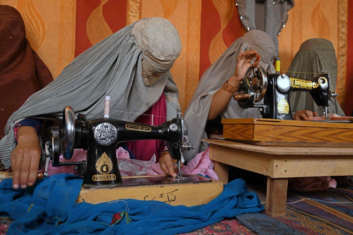 Afganas con burka trabajando en una fábrica de jabón y ropa en Kandahar