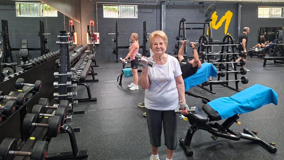 Una señora, a sus 89 años de edad, entrenando la fuerza y resistencia en el gimnasio.
