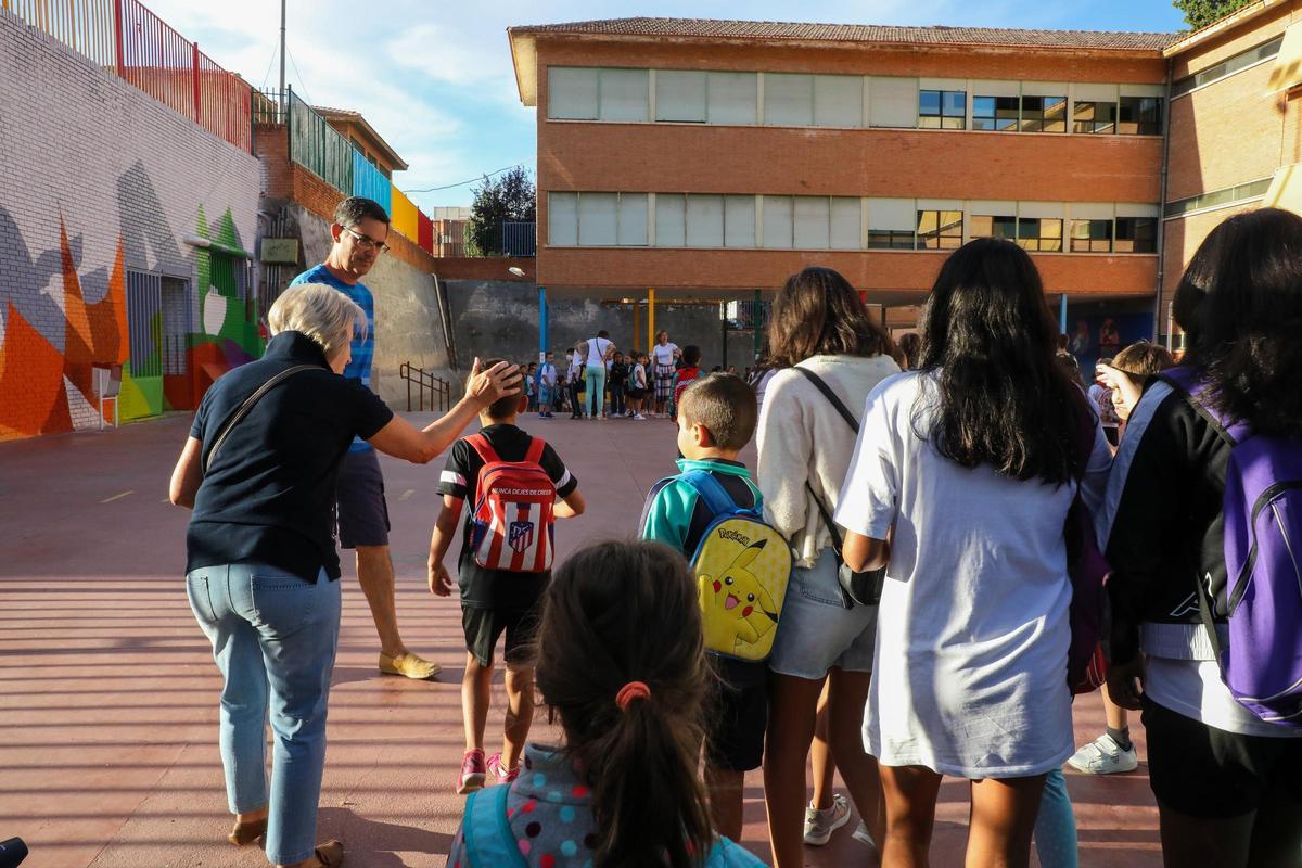 Un profesor acompaña a un grupo de alumnos a la entrada del centro escolar.