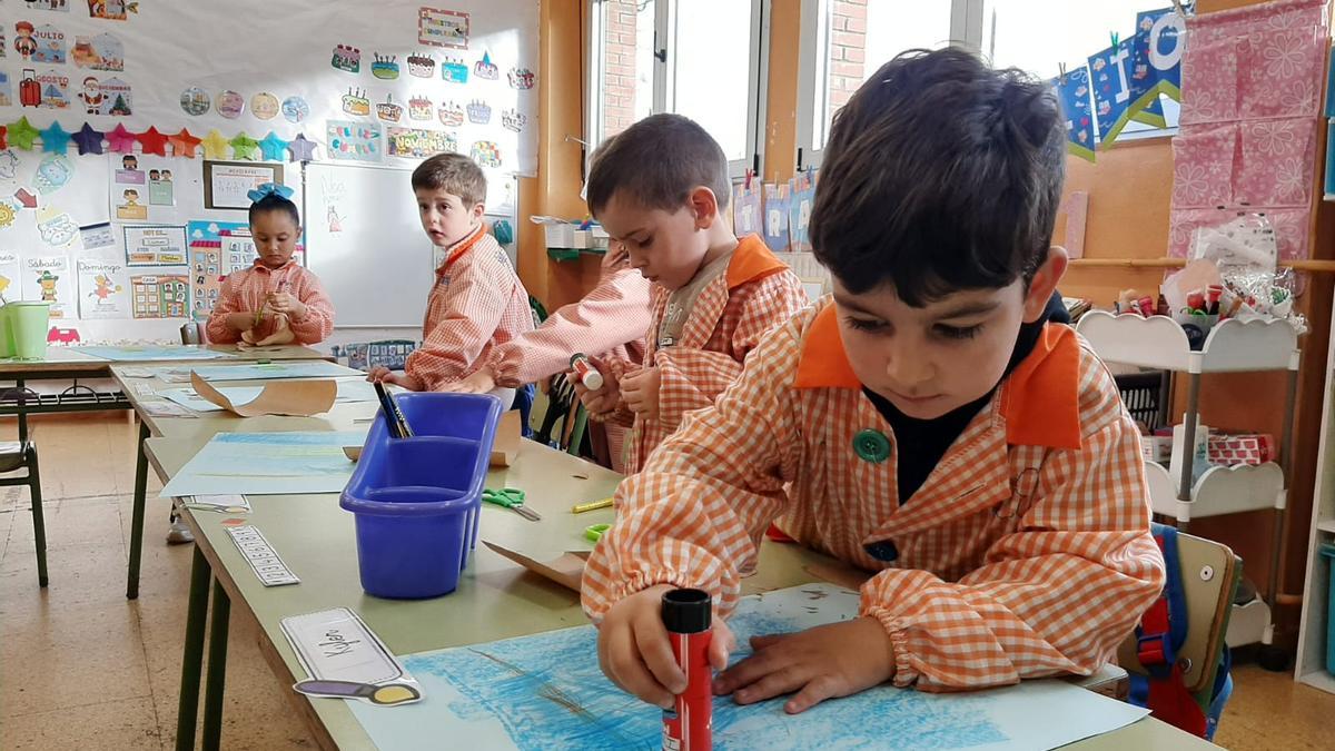 Unos niños haciendo manualidades en su colegio.