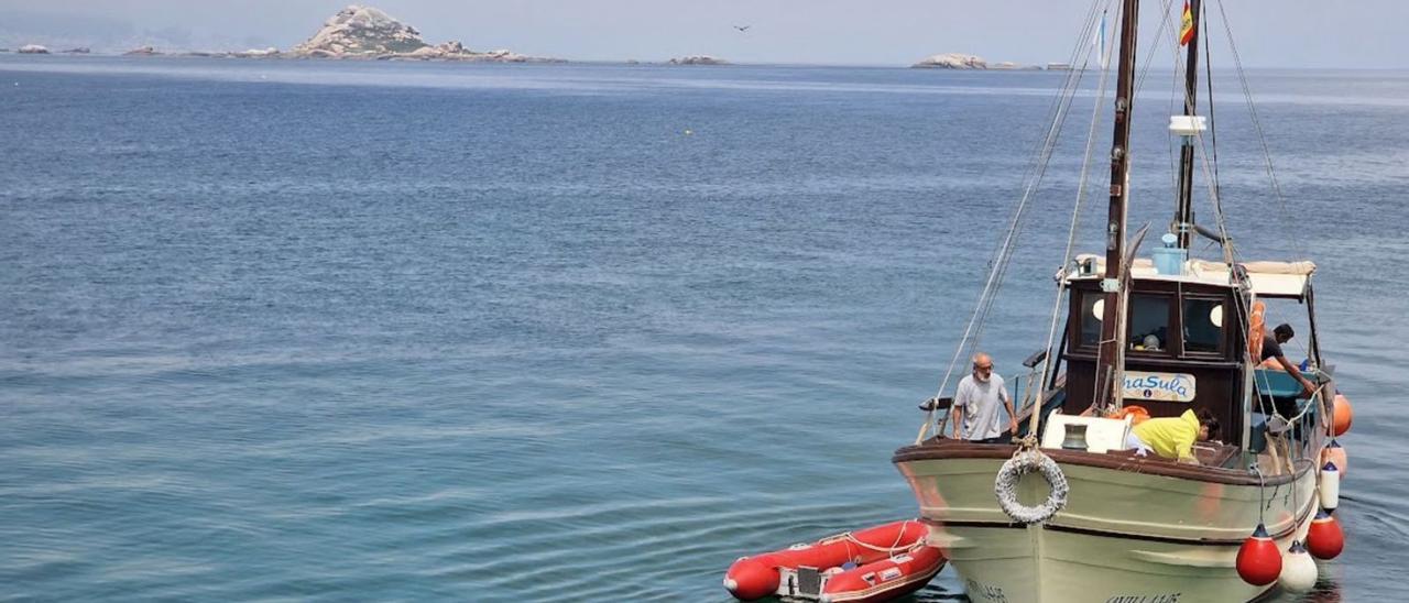 El barco tradicional “Chasula”, con Isidro Mariño en proa, en aguas de Sálvora.