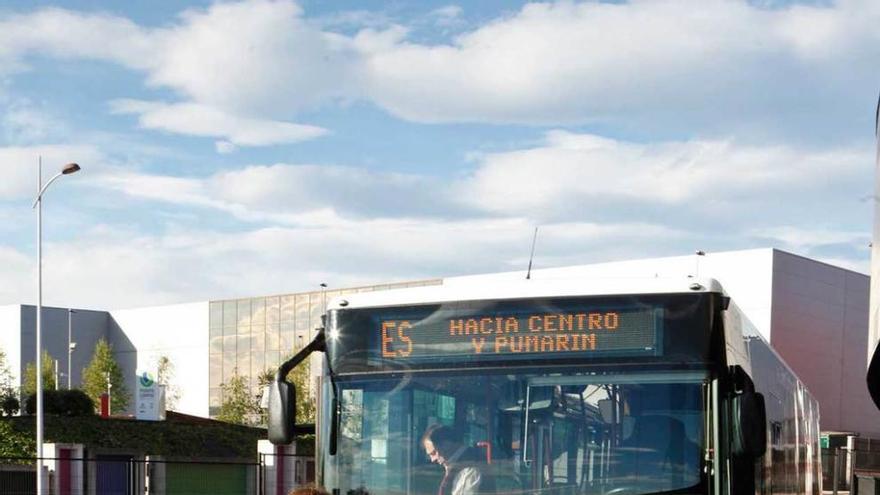 Un grupo de escolares pasa por delante de un autobús de Emtusa.