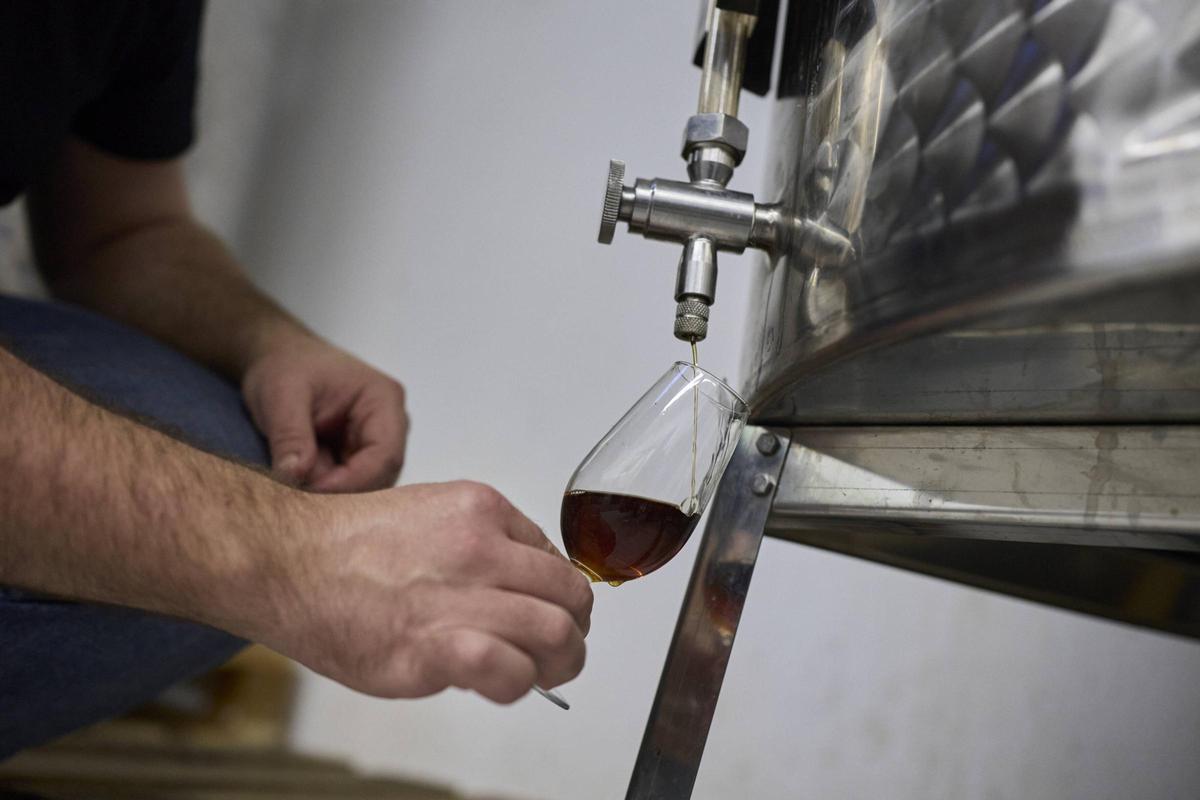 Un membre de La Sobirana extraient una mostra de ratafia.