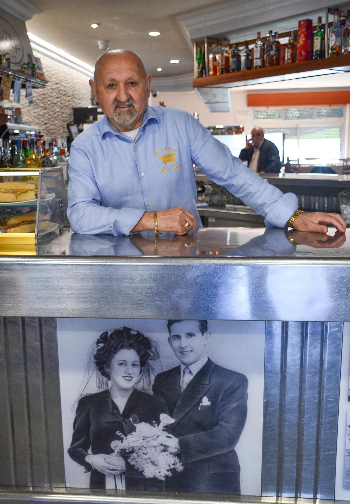 José Aurelio Rodríguez posa junto a una imagen de sus padres, una foto que se muestra en la barra.