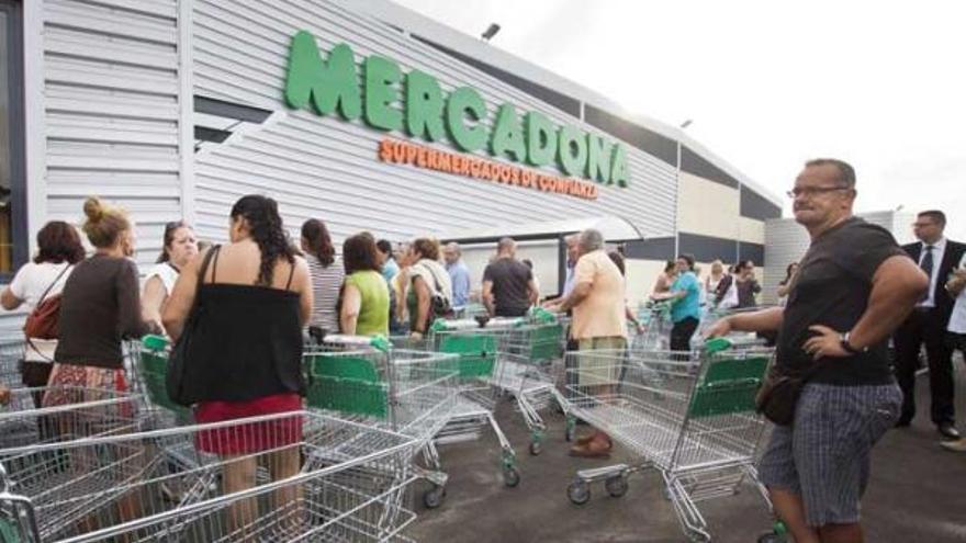 Algunos de los compradores aguardan a la puerta del supermercado a que abra sus puertas por primera vez