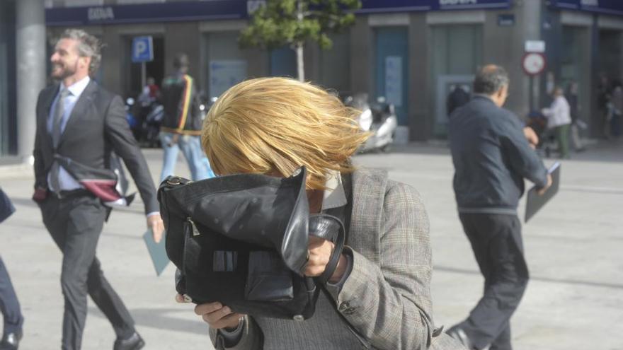 Una mujer se protege del viento en A Coruña.