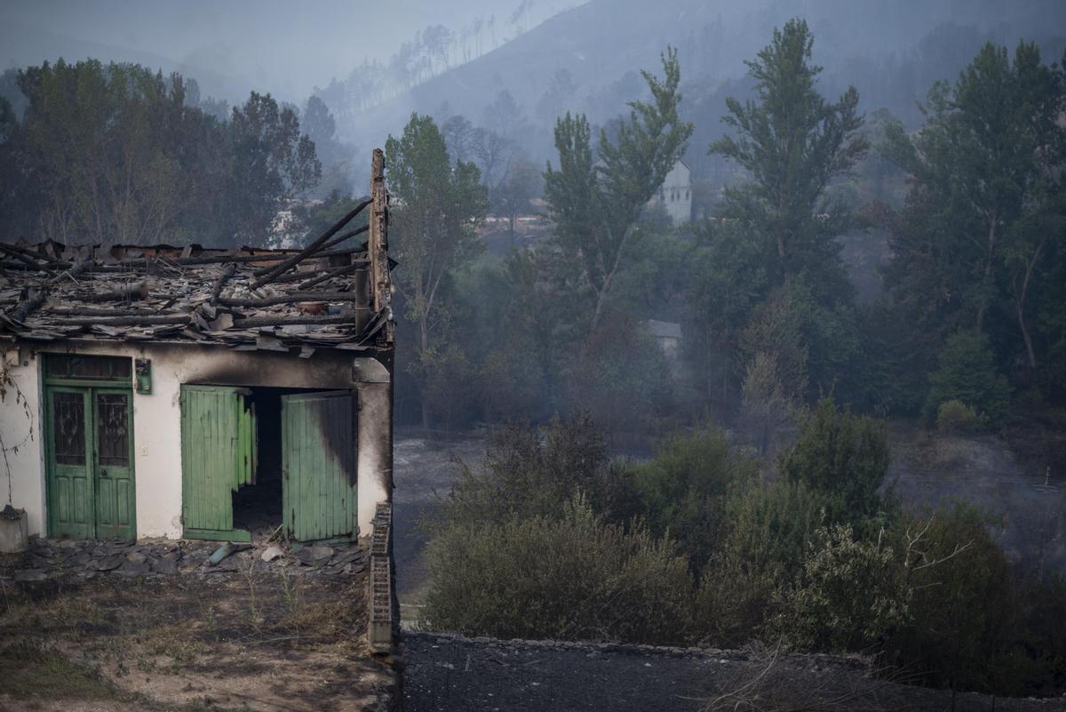 Una vivienda rodeada por la superficie calcinada en la localidad de A Veiga da Cascallá (Rubiá), este martes. EFE/ Brais Lorenzo