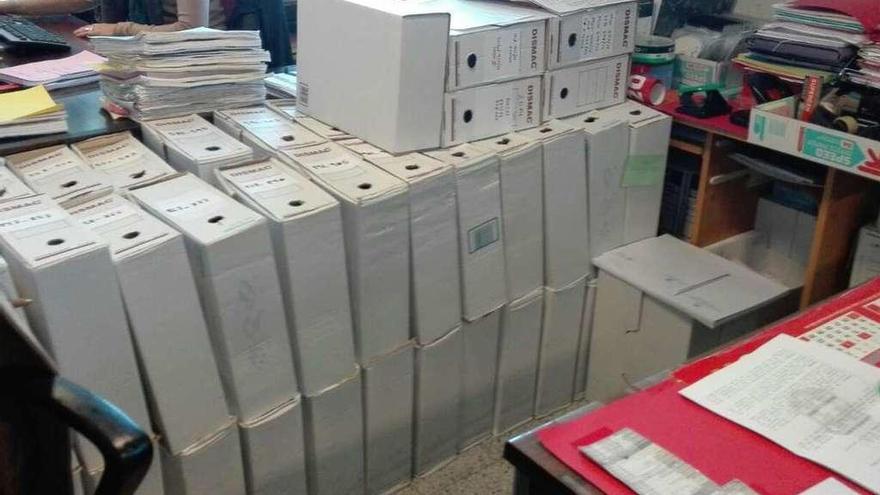 Cajas con expedientes en el suelo que avanzan y ganan espacio.