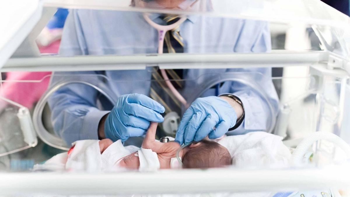 Un bebé prematuro recién nacido en la incubadora de un hospital.