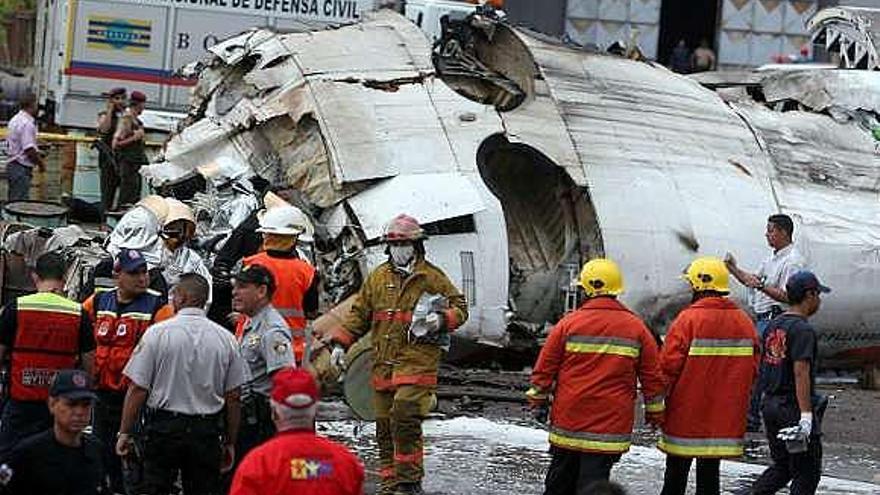 Operarios trabajan en los restos del avión en Ciudad Guayana. / efe