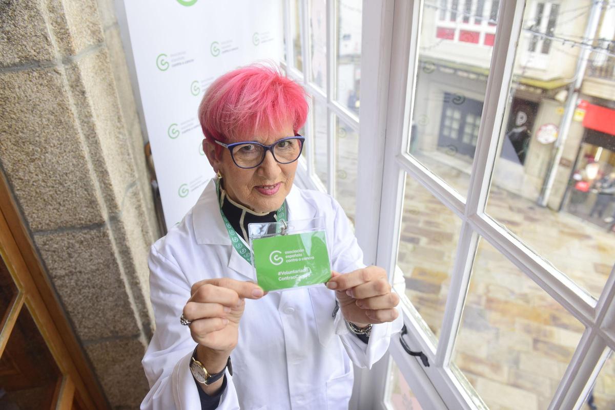 Pitusa Balseiro muestra su carné de la voluntaria de la AECC, en la sede de la asociación, en A Coruña.