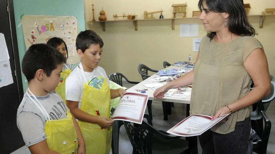 La concejala Tania García entrega diplomas de un curso de cocina a unos niños en Trabanca. // Noé Parga