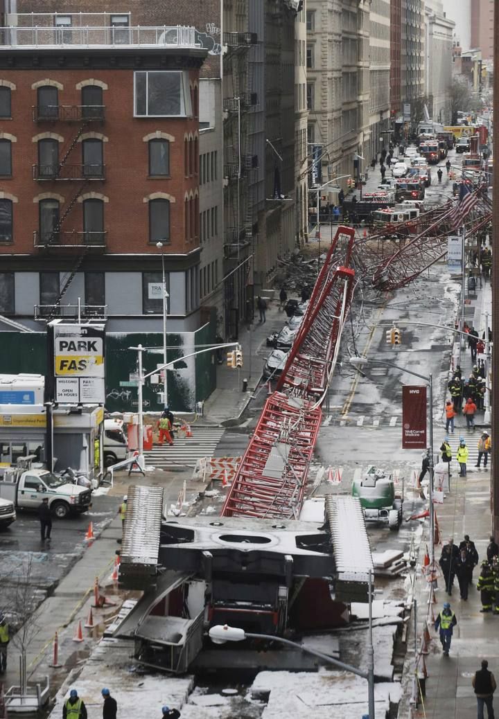 Emergency responders respond to the scene of the 565-foot-tall crane that toppled and flipped upside down stretching along nearly two city blocks in downtown Manhattan in New York