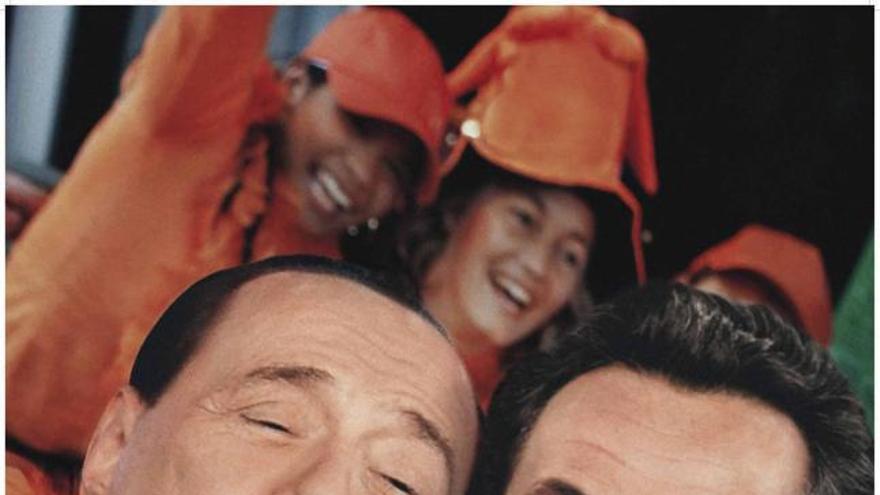 En la imagen, las caras de Silvio Berlusconi y Sarkozy muy juntas y alegres