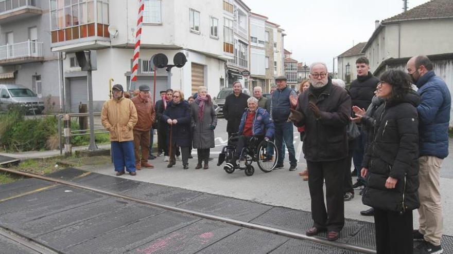 Vecinos y vecinas de Peliquín y de Catro Camiños, ayer en el paso a nivel ferroviario. |   // IÑAKI OSORIO