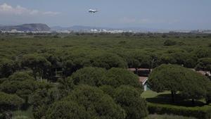 Un avión pasa por encima de La Ricarda (con la Casa Gomis en primer término) antes de aterrizar en El Prat.
