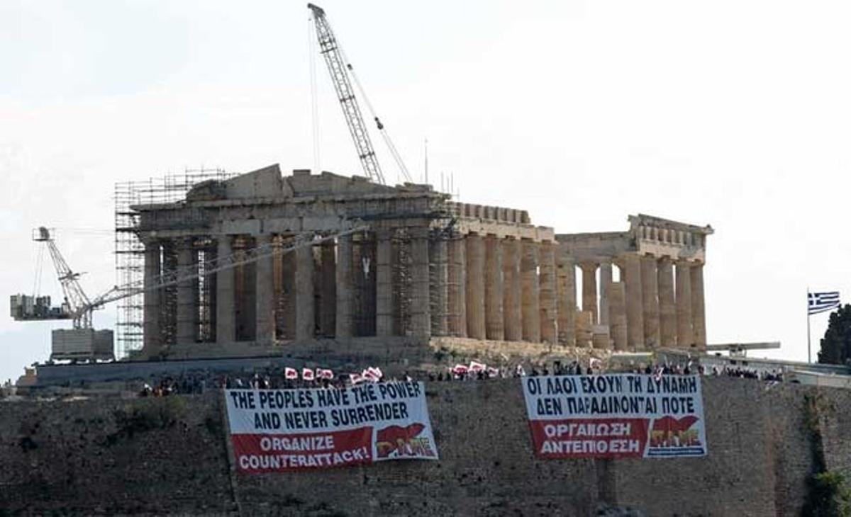 Manifestants del sindicat de treballadors afiliats al partit comunista PAME grec mantenen penjada una enorme pancarta al davant del Partenó a l’Acròpolis d’Atenes, en protesta pels plans del govern per a un nou paquet de mesures d’austeritat.