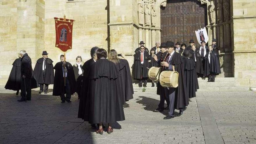 Miembros de la Asociación de Amigos de la Capa en el pórtico de los reyes d e la iglesia de San Juan