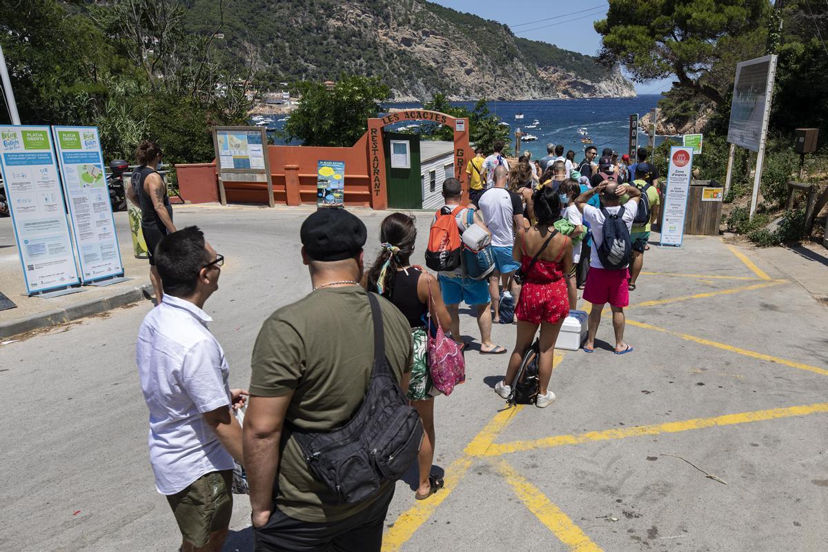 Colas de bañistas esperan su turno para bañarse en una playa en Begur, el pasado verano.