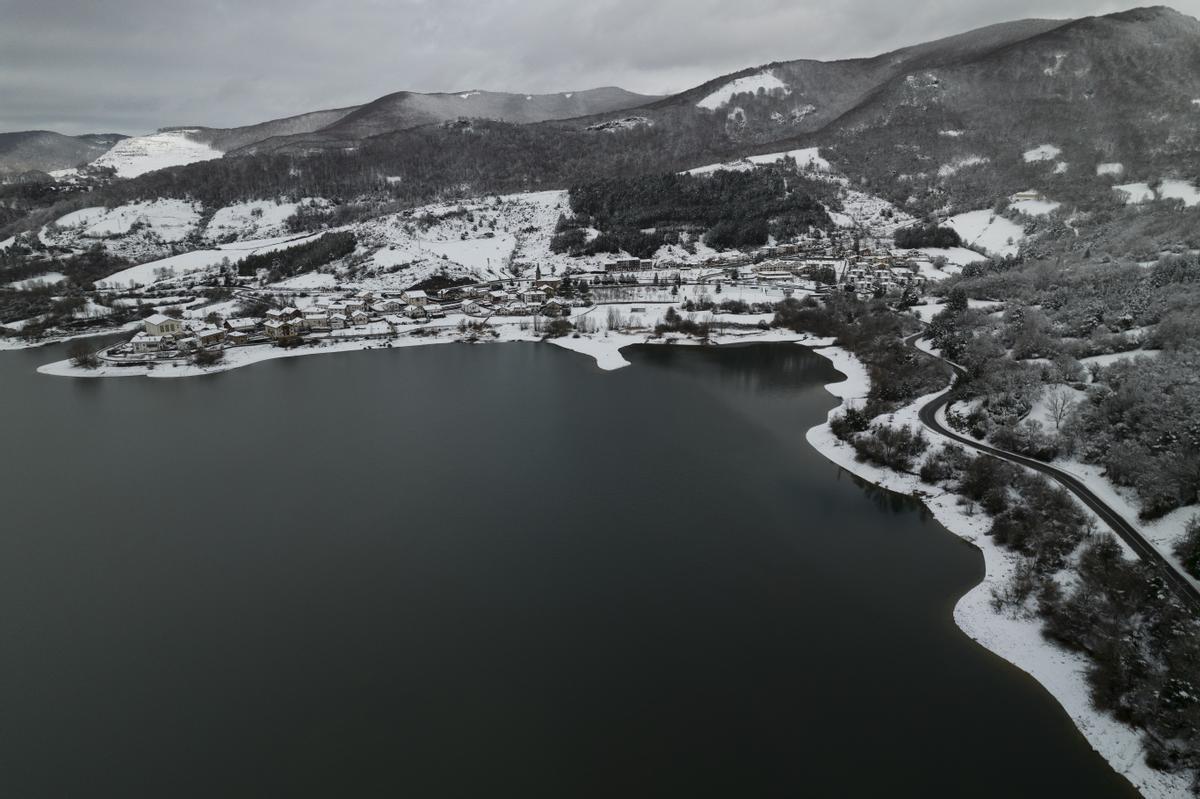 GRAFCAV4153. EUGUI, 18/01/2023.- Vista del pueblo de Eugui junto a las aguas del pantano en una jornada donde la Agencia Estatal de Meteorología ha dado alerta naranja por nieve este miércoles para toda Navarra salvo la Ribera y de nivel amarillo por riesgo de aludes para Pirineos. Según indica la Aemet, en Pirineos se puede alcanzar un espesor de nieve de 20 centímetros en 24 horas a partir de los 900-1000 metros de altitud, y en la vertiente cantábrica y el centro de la comunidad, 10 centímetros en 24 horas, por encima de los 500 metros en la vertiente cantábrica y de los 700 en el centro de la comunidad, aunque la cota de nieve estará situada en torno a los 300-400 metros. EFE/ Jesús Diges