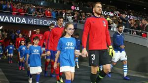 Los jugadores del Atlético de Madrid saltan al campo acompañados de niños