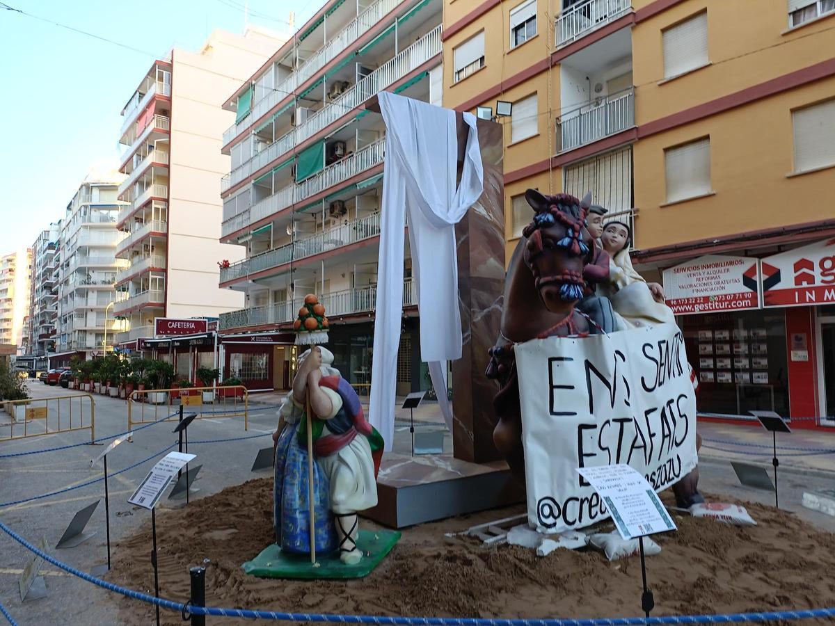 La comisión exhibe carteles contra el artista en su monumento.