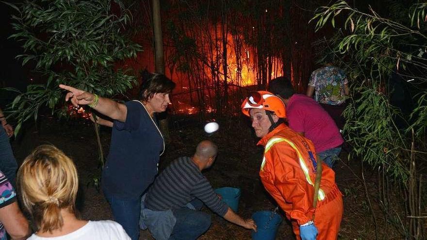 Vecinos y cuadrillas, en la extinción de un incendio forestal en el bosque de O Frendoal, Aldán. // G.Núñez