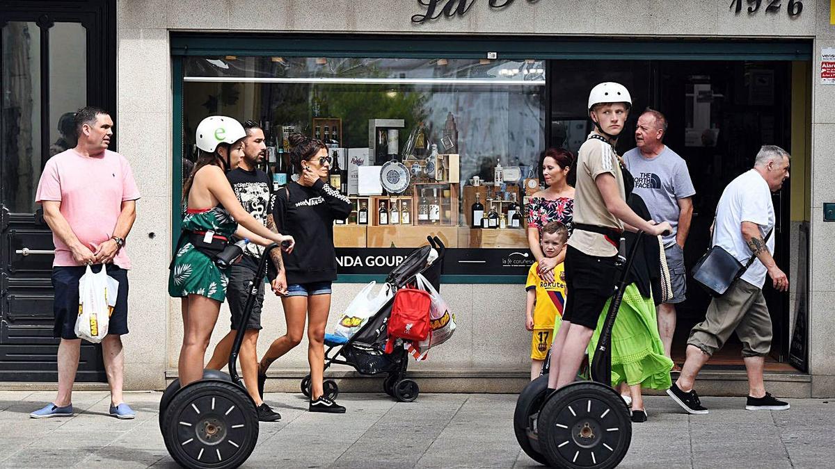 Turistas con vehículos de movilidad personal en el centro de A Coruña.   | // VÍCTOR ECHAVE