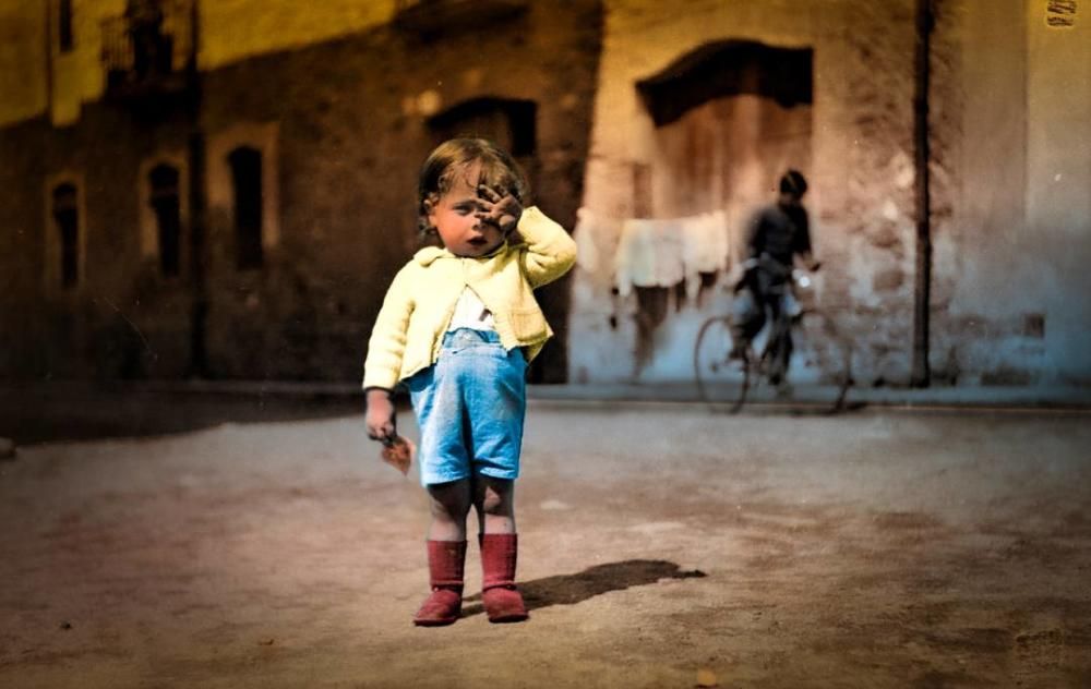 Foto colorejada digitalment deuna em blanc i negre on es veu un retrat de Josep Maria Crescenti Gironella a la plaça del Veïnat. Salt 1939